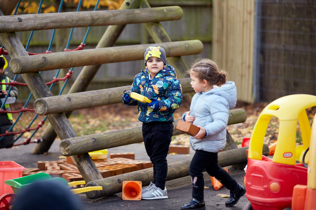 Nursery student playing with outdoor equipment