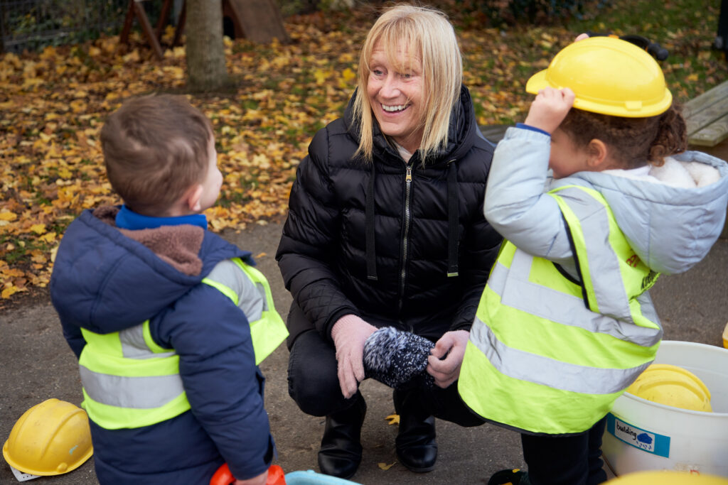 Nursery students talking to staff member