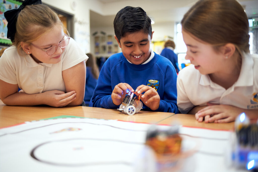 Students with a small robot sat in a classroom