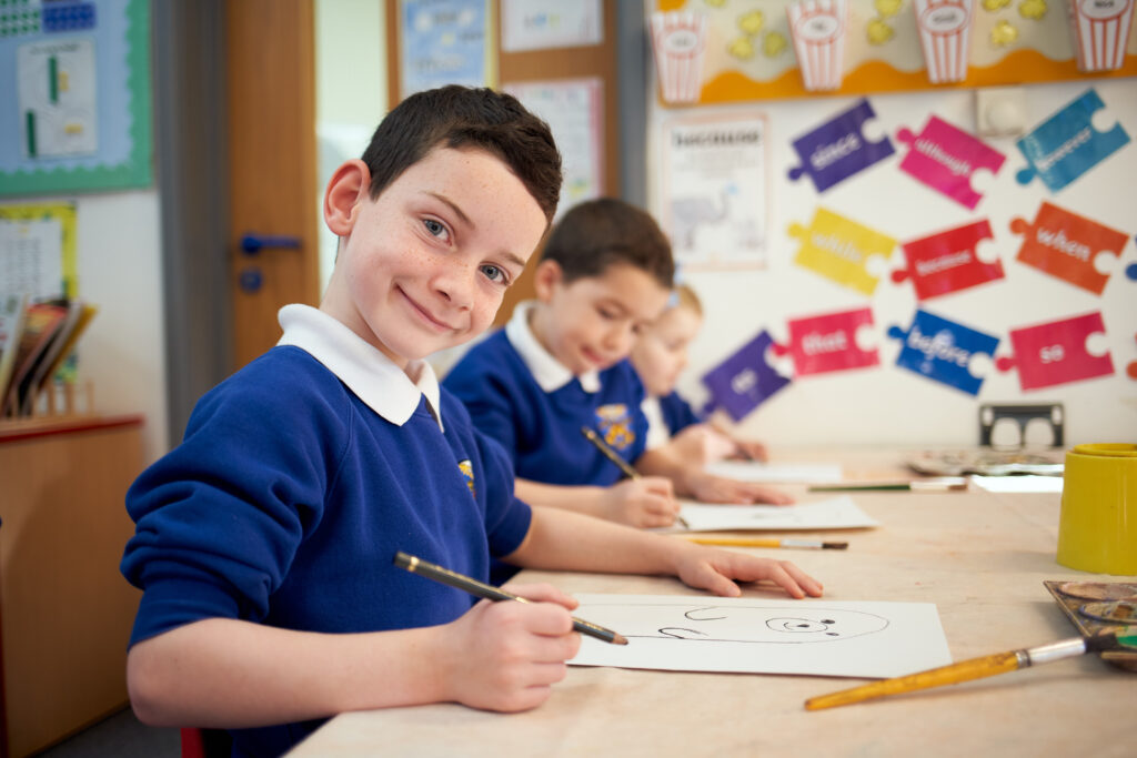Student smiling at the camera in a classroom