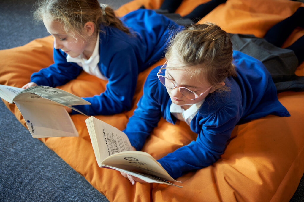 Students reading books on a beanbag chair